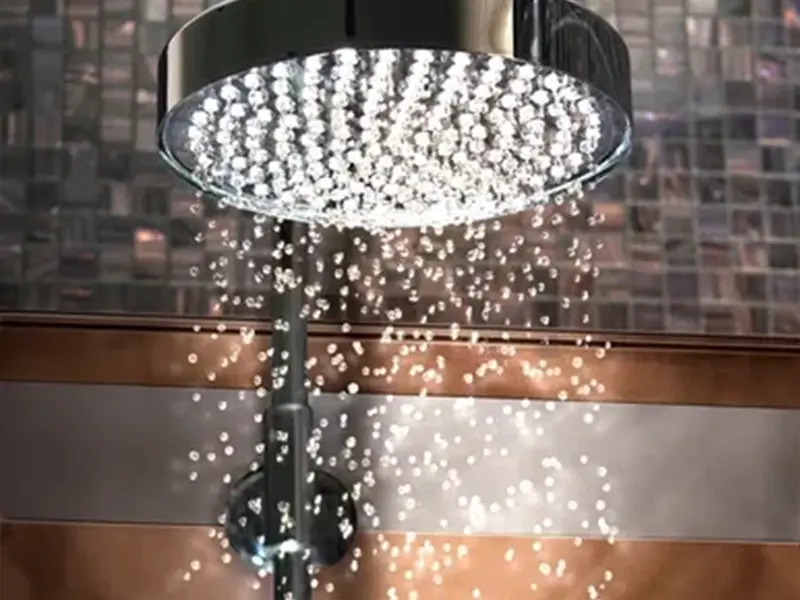 A shower head with lights shining on it.