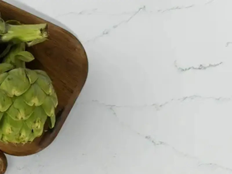 A wooden bowl with some green food on top of it